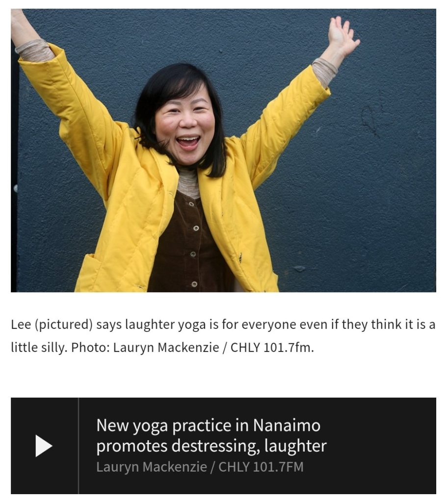 Crystal Lee wearing a yellow coat, smiling with arms raised to demonstrate laughter yoga